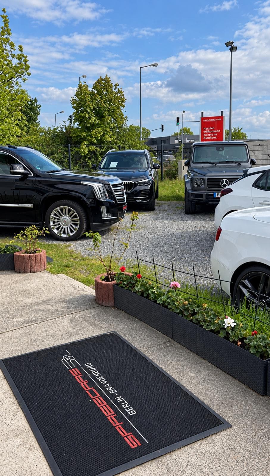Premium-Fahrzeuge auf dem Spreecars-Hof mit Eingangsmatte